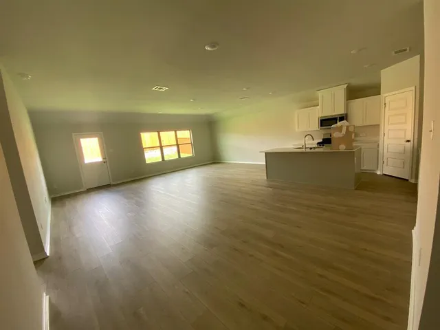 a view of kitchen and hall with wooden floor