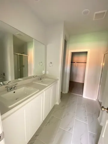 a spacious bathroom with a double vanity sink and a mirror