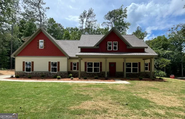 a front view of a house with a yard and trees
