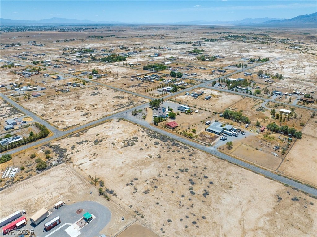 4580 Lawrence Road Pahrump, NV 89048 - Photo 36 of 40 An aerial panorama reveals a vast, sun-drenched landscape with residential properties and mountain views.