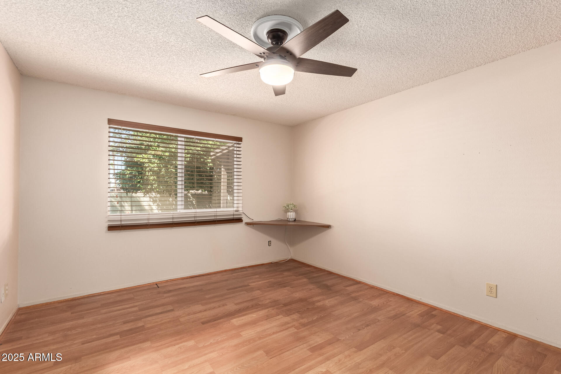131 North Higley Road, Unit 1 Mesa, AZ 85205 - Photo 18 of 32 an empty room with a window and ceiling fan