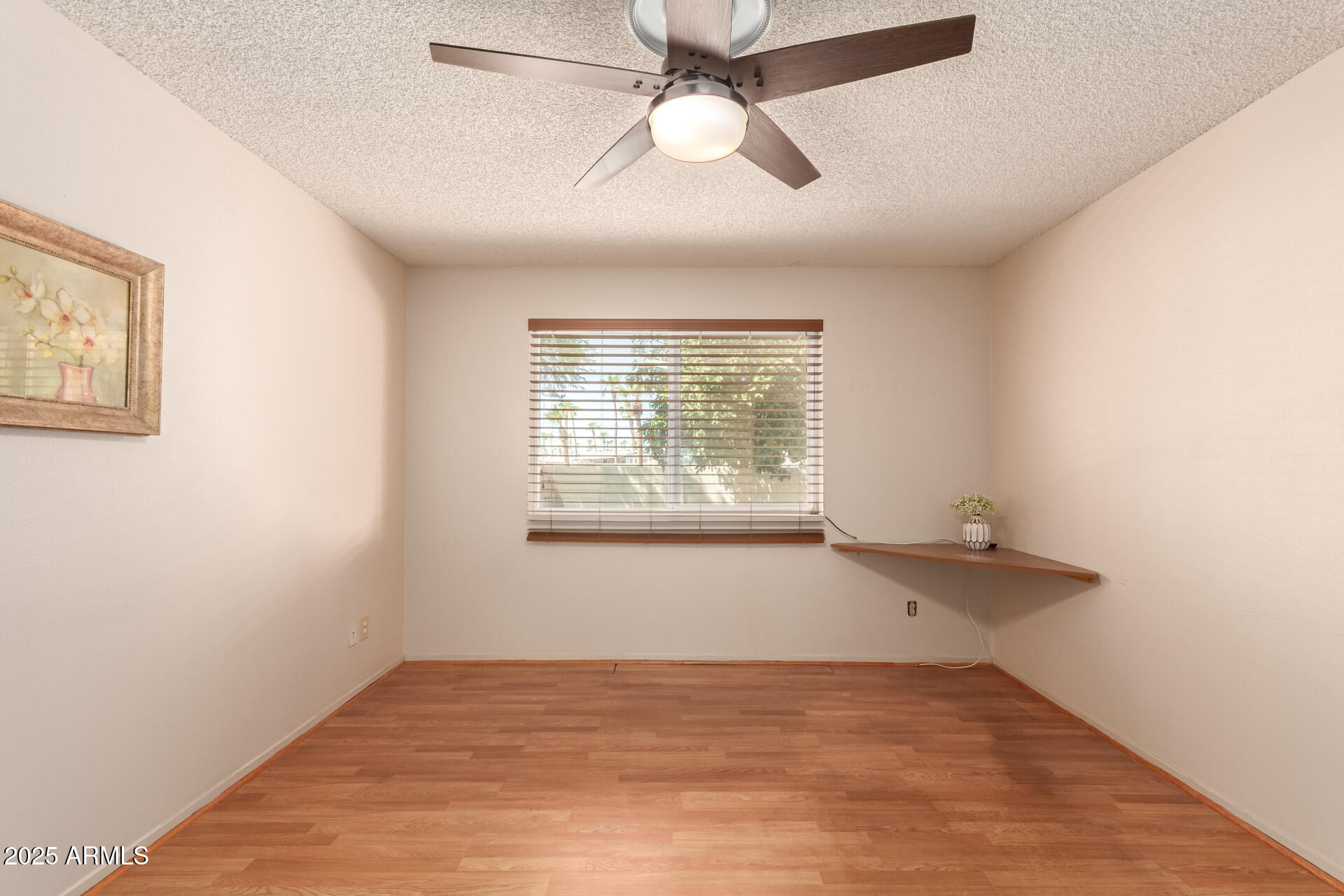 131 North Higley Road, Unit 1 Mesa, AZ 85205 - Photo 19 of 32 an empty room with a window and ceiling fan