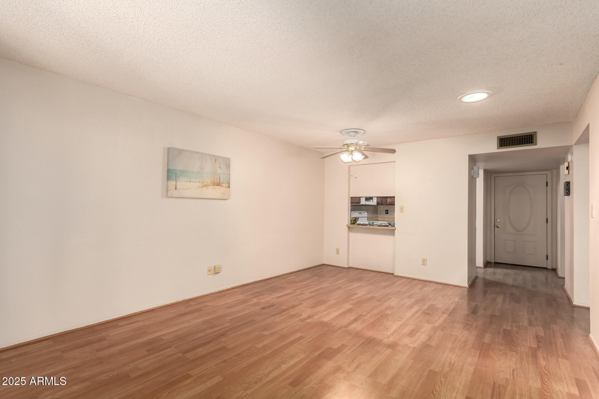 131 North Higley Road, Unit 1 Mesa, AZ 85205 - Photo 4 of 32 a view of a big room with wooden floor and a ceiling fan
