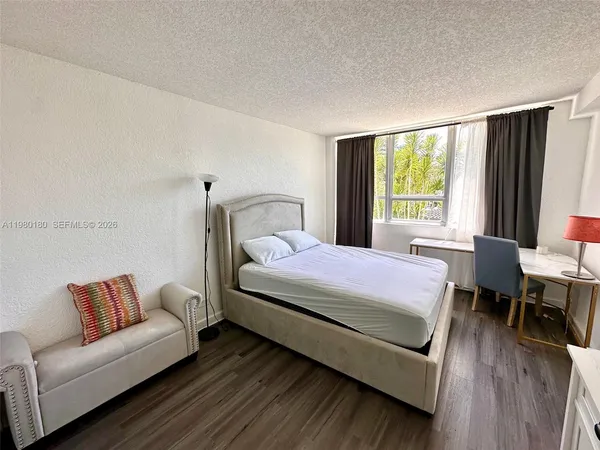 a bedroom with a bed couch and a large window