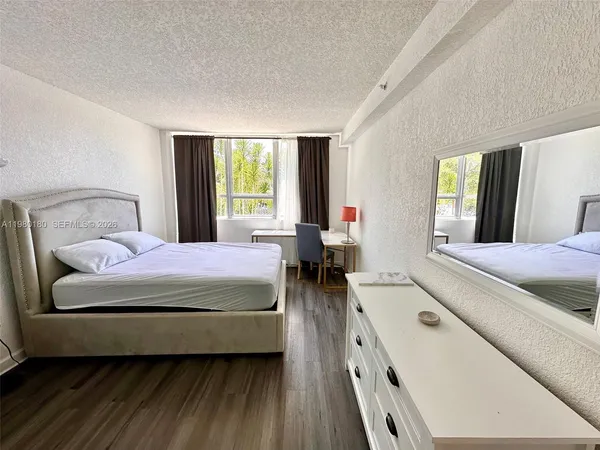 a bedroom with a bed and a large window