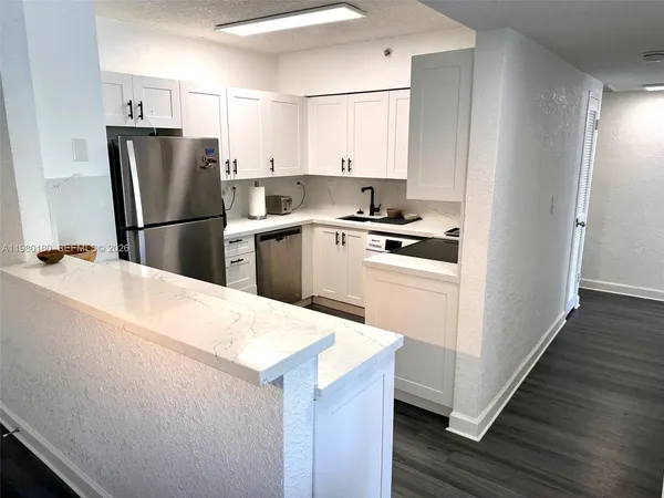 a kitchen with a refrigerator sink and cabinets