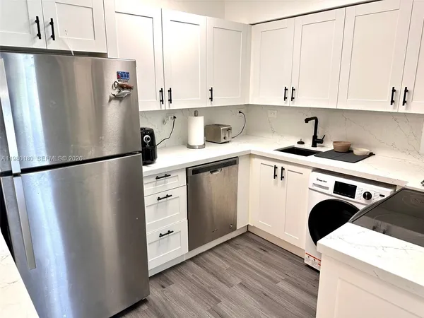 a kitchen with stainless steel appliances a refrigerator sink and cabinets