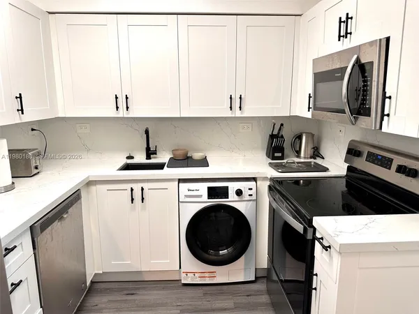 a kitchen with a sink a stove and cabinets