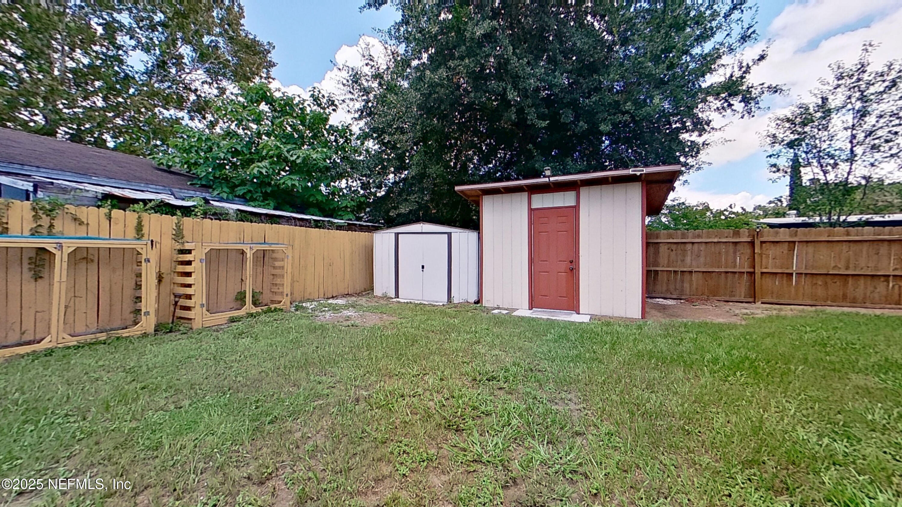 399 Toccoa Road Orange Park, FL 32073 - Photo 23 of 31 a backyard of a house with large trees and a wooden fence