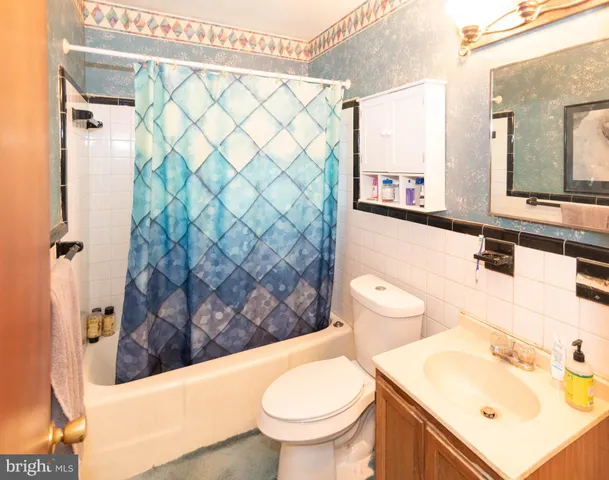 a bathroom with a sink a toilet and shower curtain