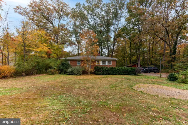a front view of a house with yard and trees