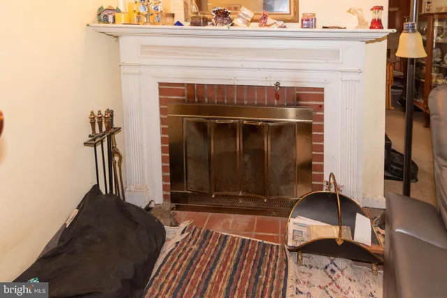 a living room with a fireplace furniture and a ceiling fan