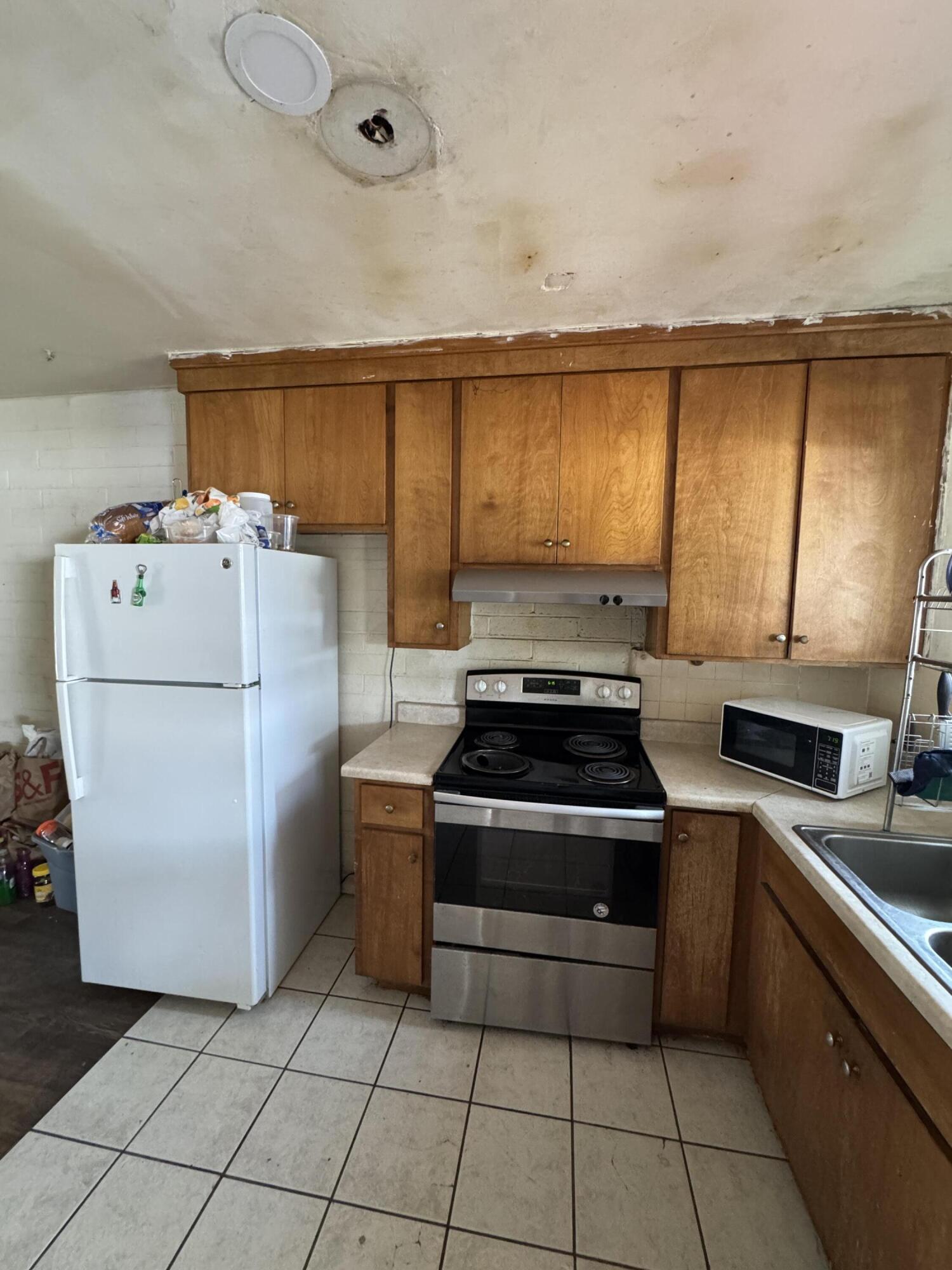 704 North Floral Street Visalia, CA 93291 - Photo 34 of 51 a kitchen with a stove top oven cabinets and a refrigerator