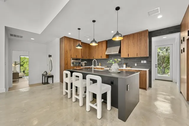 a kitchen with kitchen island granite countertop a sink a center island and appliances