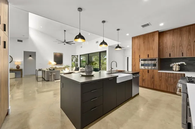 a kitchen with stainless steel appliances granite countertop a sink and a refrigerator