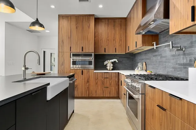 a kitchen with stainless steel appliances granite countertop a stove a sink and a microwave