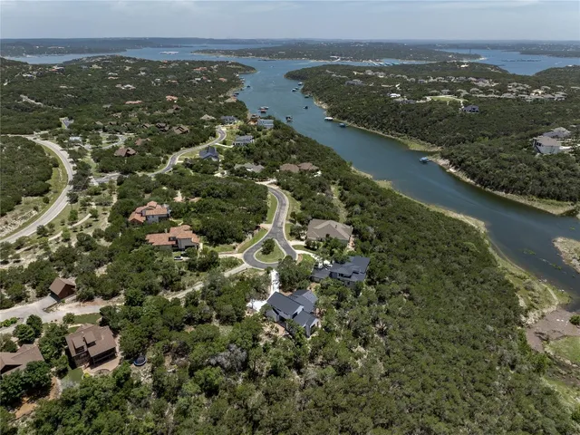 an aerial view of residential houses with outdoor space and lake view