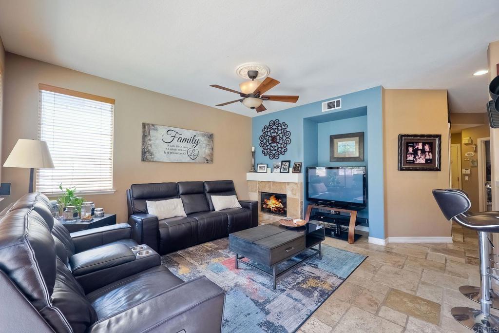 6738 Solandra Drive Carlsbad, CA 92011 - Photo 8 of 11 a living room with furniture a fireplace and a window