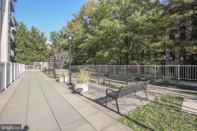 a roof deck with table and chairs and wooden fence