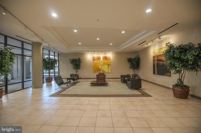 a lobby with furniture and potted plants