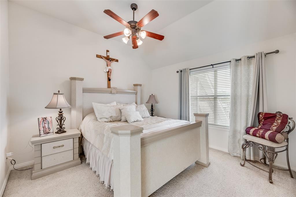 6810 Amesbury Lane Rowlett, TX 75089 - Photo 13 of 22 a bedroom with a bed and a chandelier