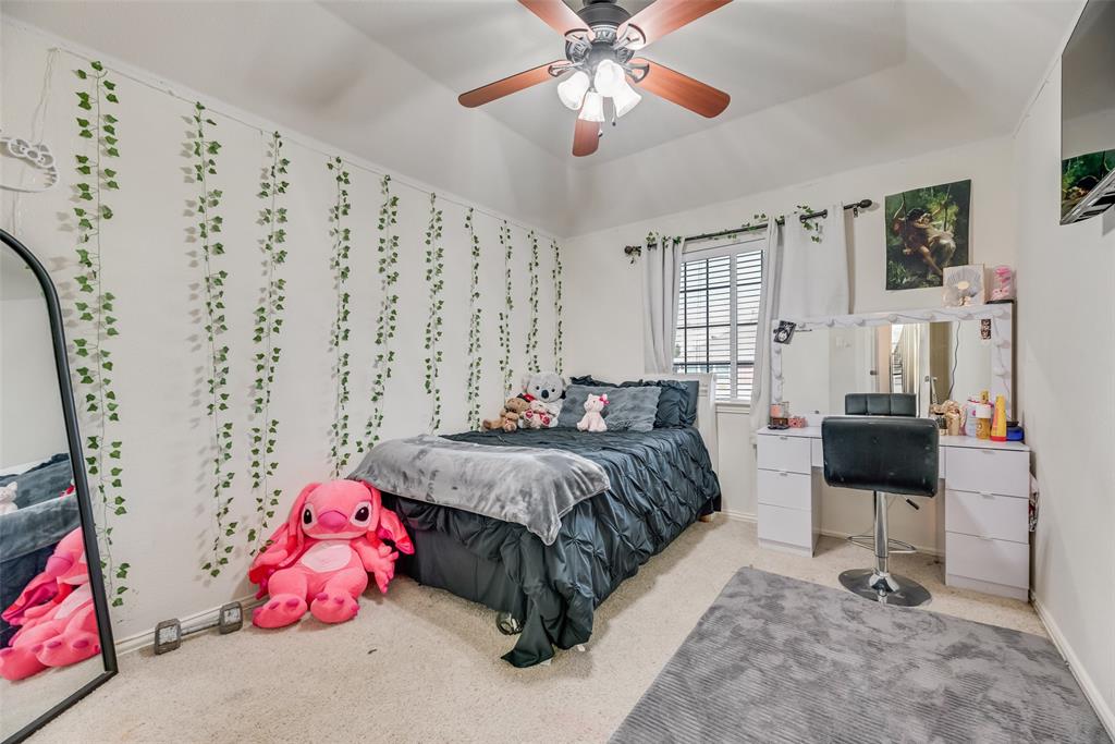 6810 Amesbury Lane Rowlett, TX 75089 - Photo 8 of 22 a bedroom with a bed and a chandelier