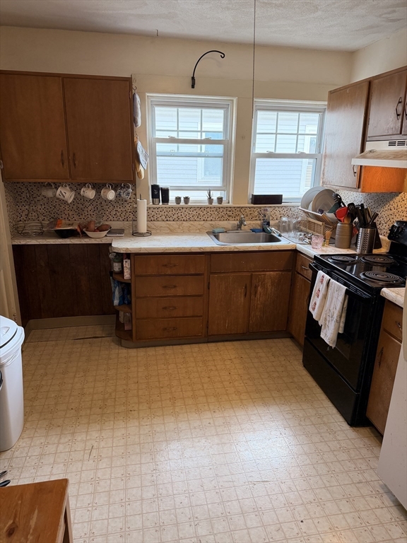 49 Sunset Road, Unit 49 Somerville, MA 02144 - Photo 14 of 24 a kitchen with sink a window and cabinets