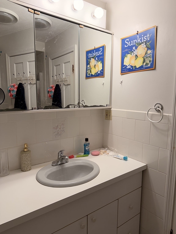 49 Sunset Road, Unit 49 Somerville, MA 02144 - Photo 24 of 24 a bathroom with a sink mirror and vanity