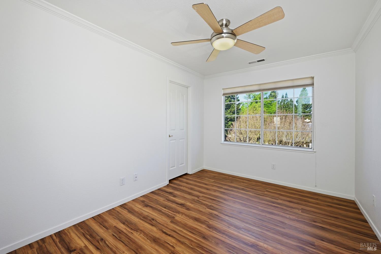 1005 Woodlake Drive Santa Rosa, CA 95405 - Photo 17 of 28 an empty room with wooden floor fan and windows