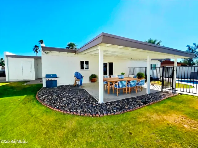 a view of a house with swimming pool and sitting area