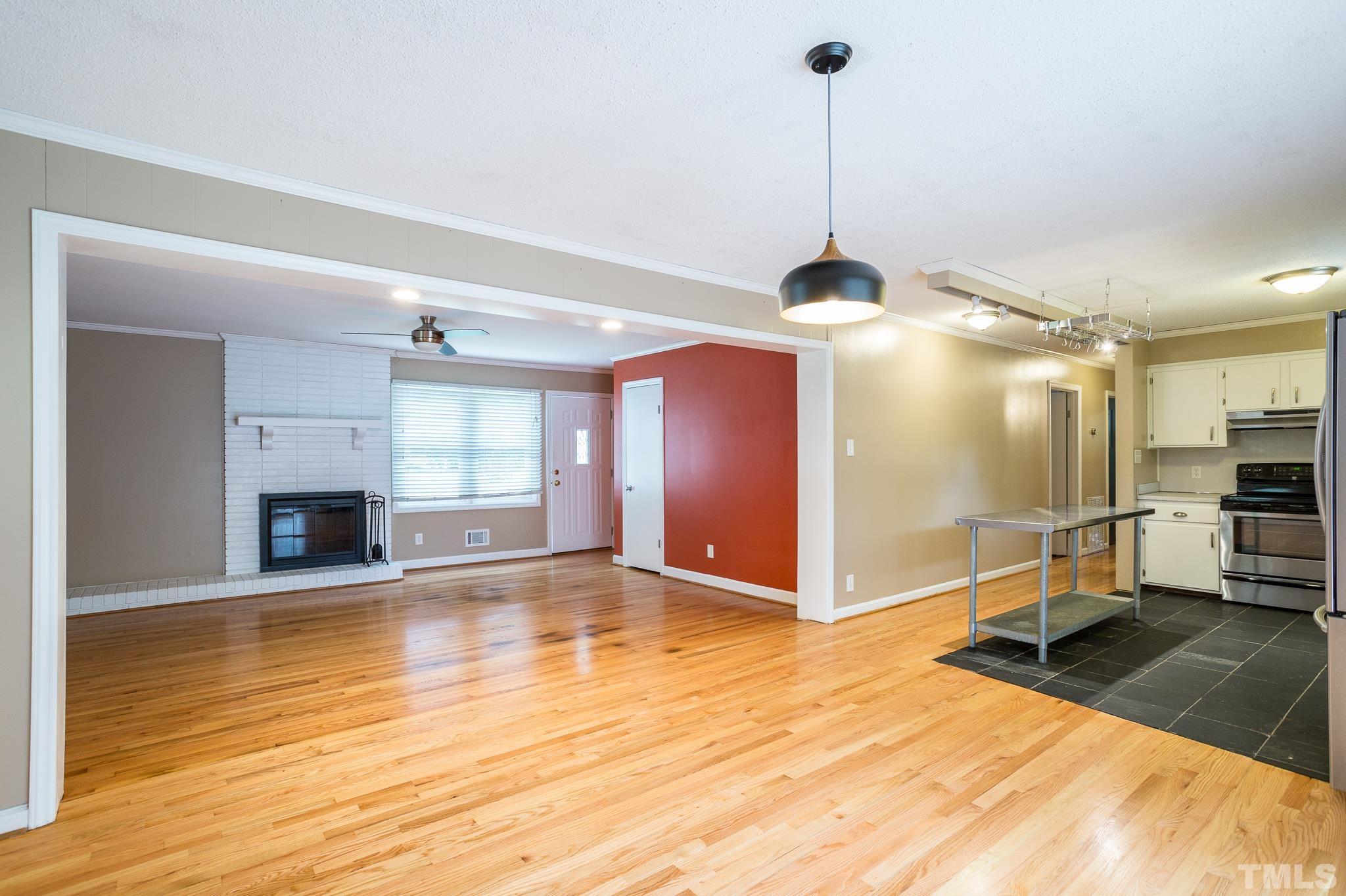 3620 Marsh Creek Road Raleigh, NC 27604 - Photo 13 of 25 a view of a livingroom with a fireplace a chandelier and wooden floor