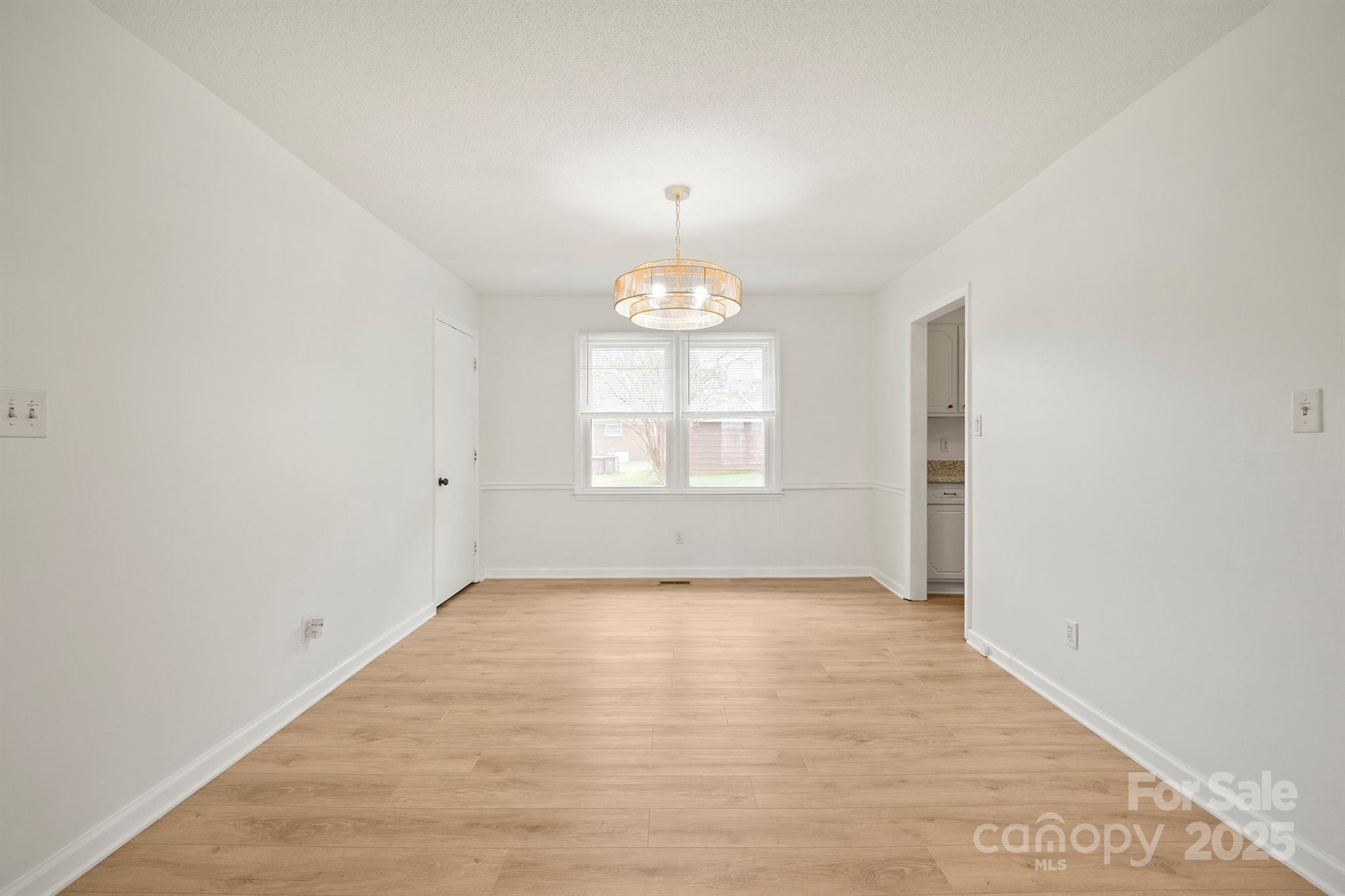 303 Windy Rush Road Kannapolis, NC 28081 - Photo 11 of 30 an empty room with chandelier fan and windows