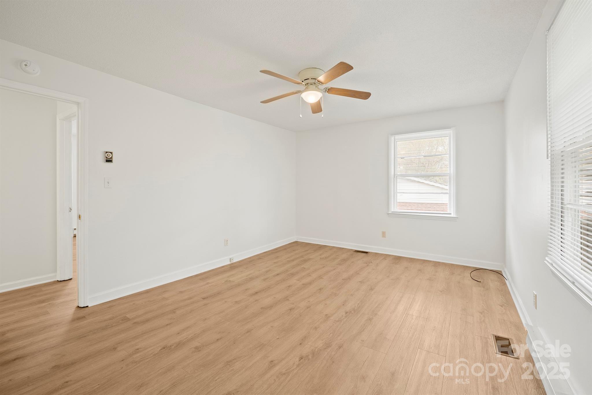 303 Windy Rush Road Kannapolis, NC 28081 - Photo 22 of 30 a view of empty room with wooden floor and fan