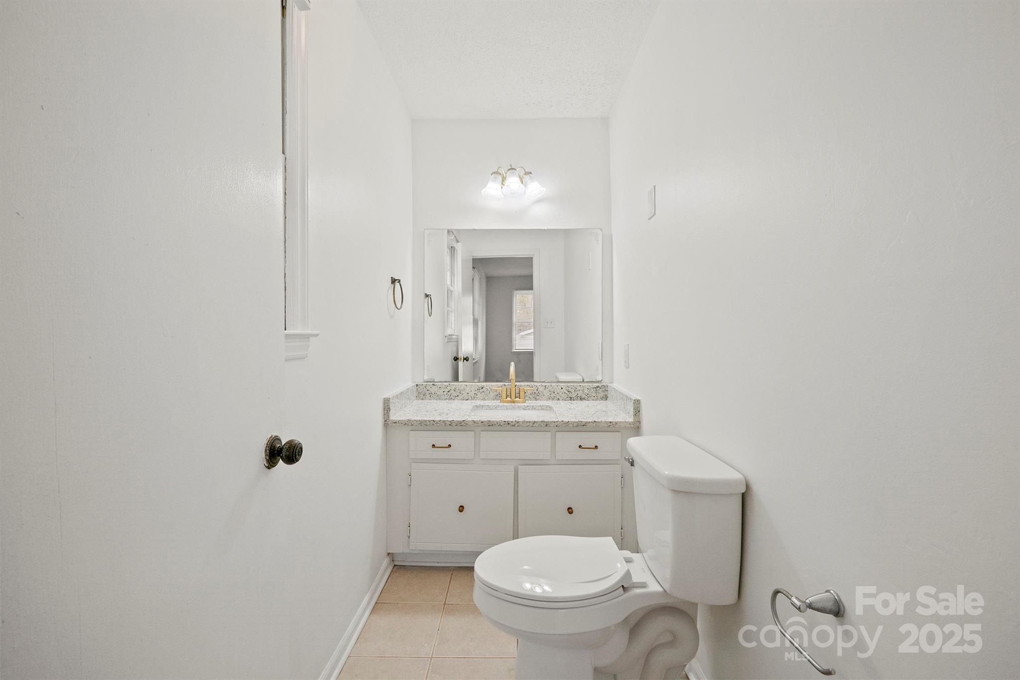 303 Windy Rush Road Kannapolis, NC 28081 - Photo 23 of 30 a bathroom with a granite countertop toilet a sink and mirror
