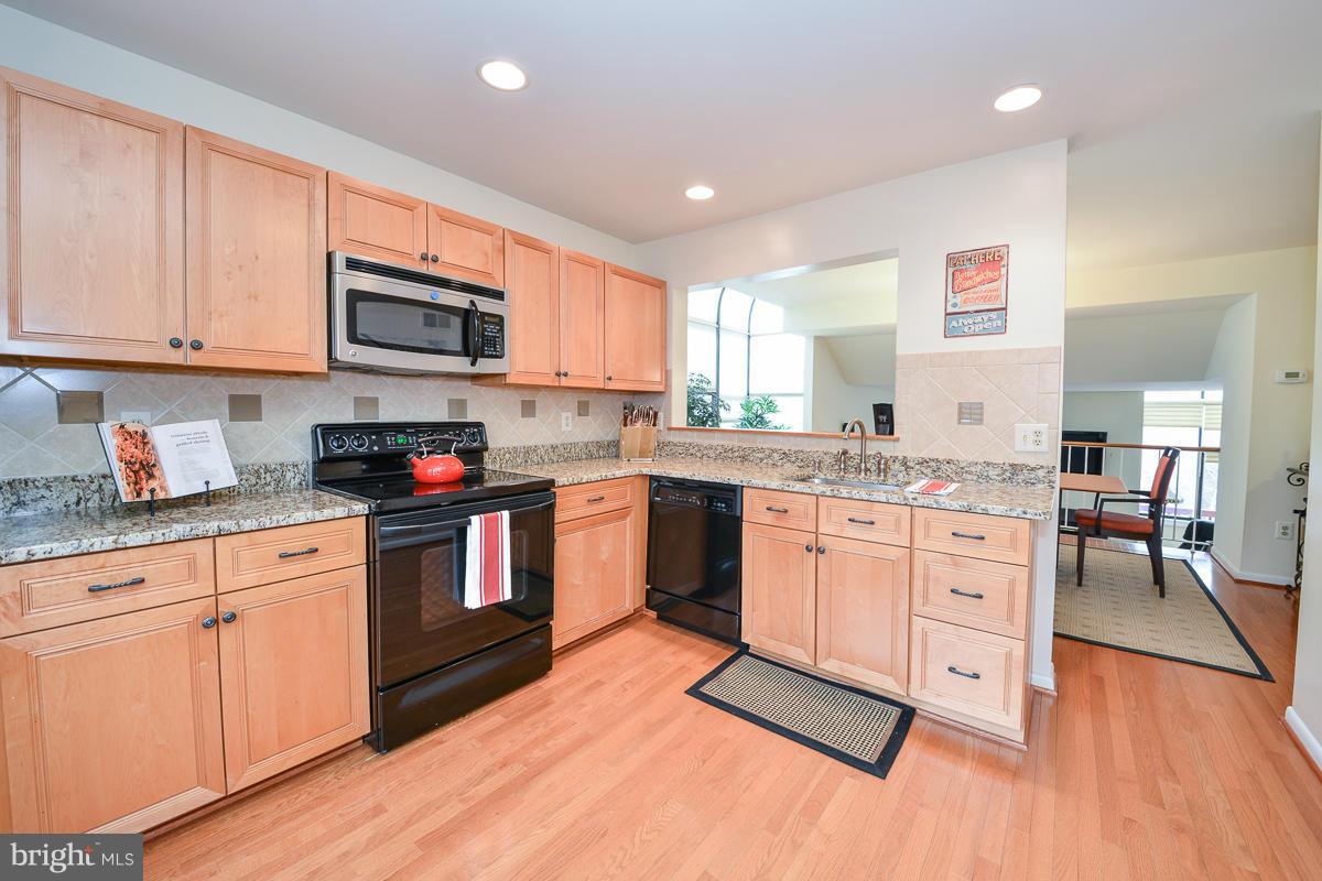 11002 Thrush Ridge Road Reston, VA 20191 - Photo 8 of 29 a kitchen with stainless steel appliances granite countertop a stove sink and cabinets