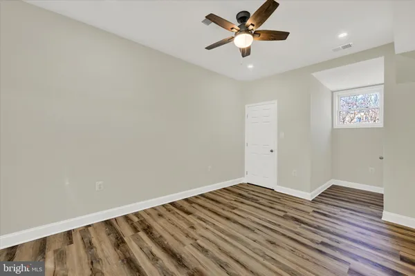 a view of a big room with wooden floor and a ceiling fan