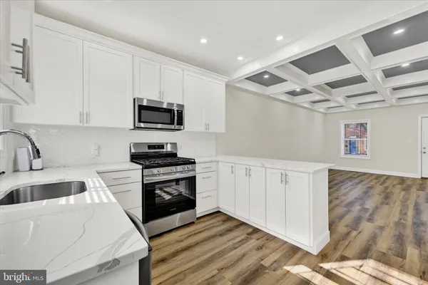 a kitchen with granite countertop a sink stove and microwave