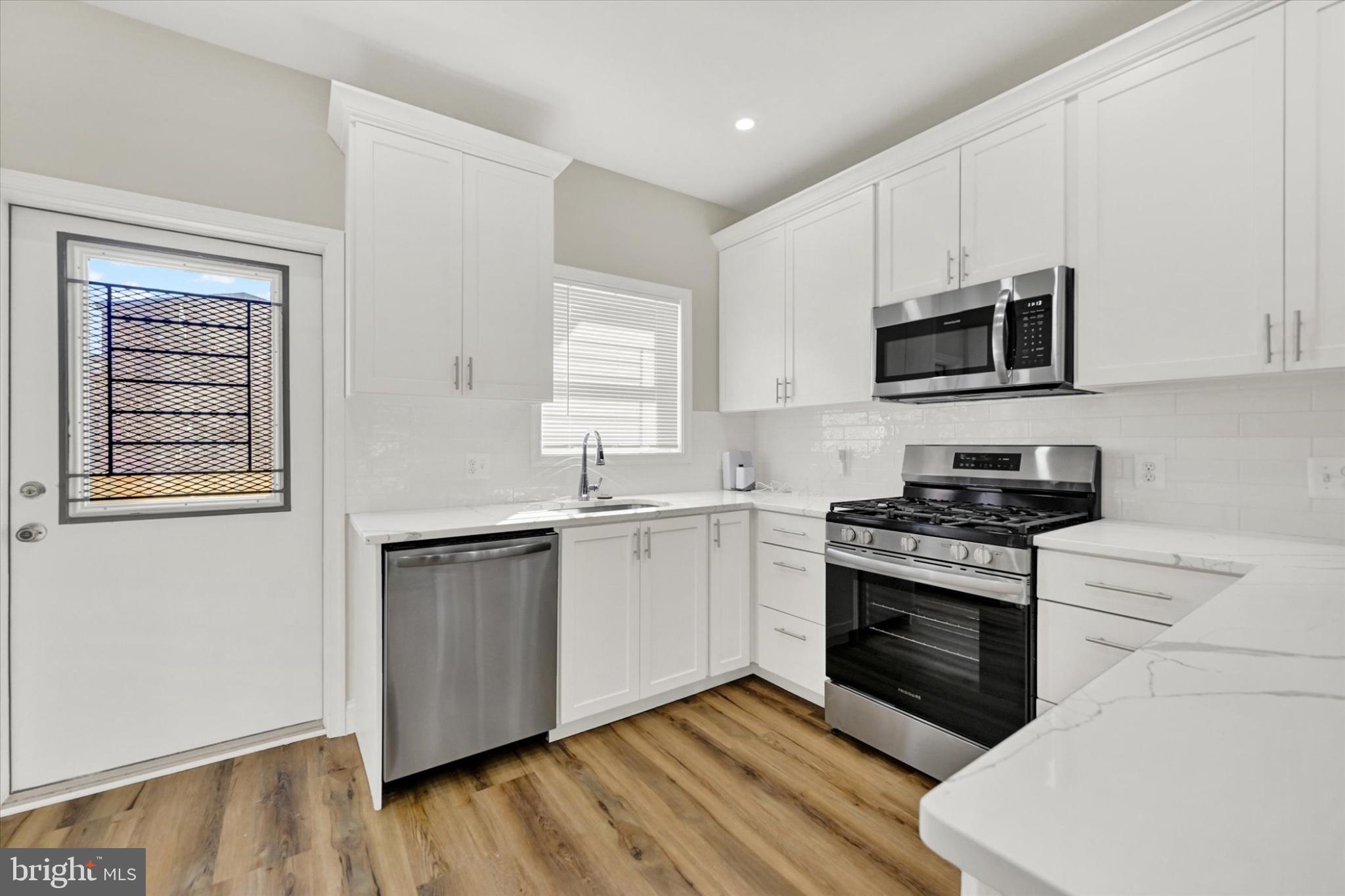 119 North Poppleton Street Baltimore, MD 21201 - Photo 25 of 41 a kitchen with stainless steel appliances white cabinets a sink and a stove