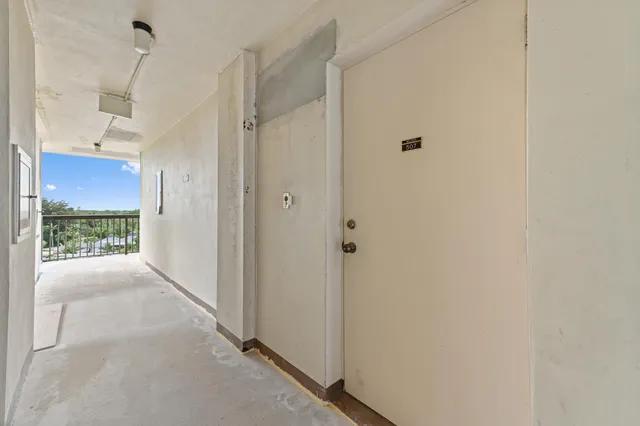 a view of a hallway with wooden floor and a bathroom