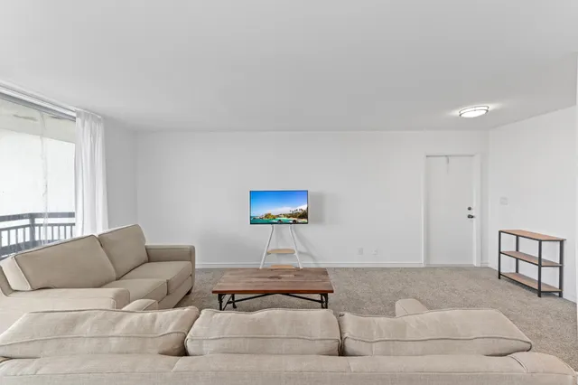 a living room with furniture a rug and a window