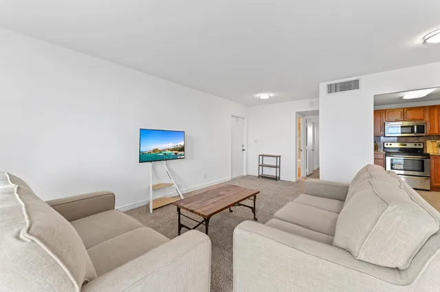 a living room with furniture a rug and a flat screen tv