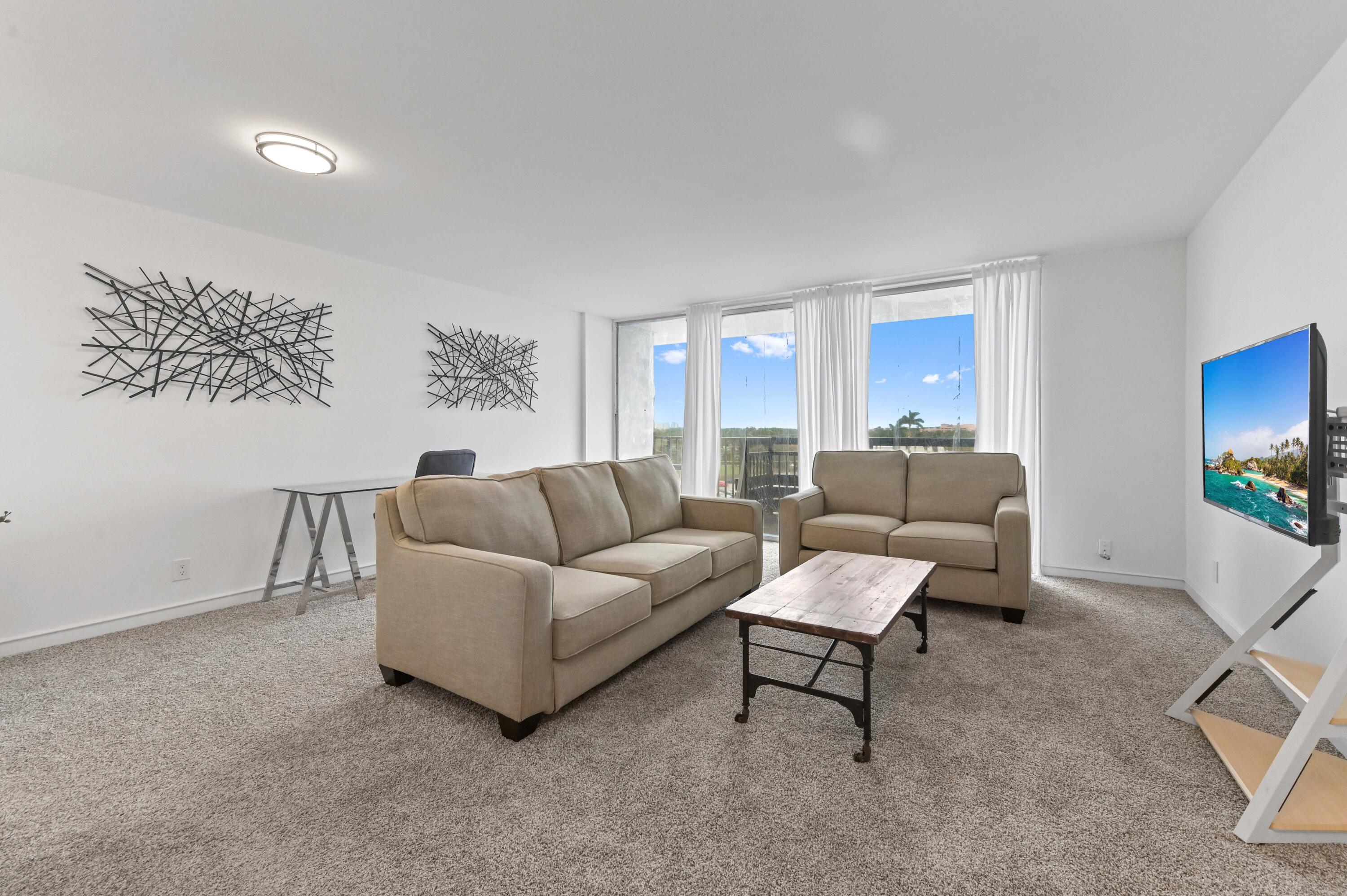 555 Northwest 4th Avenue, Unit 5070 Boca Raton, FL 33432 - Photo 8 of 29 a living room with furniture and a flat screen tv