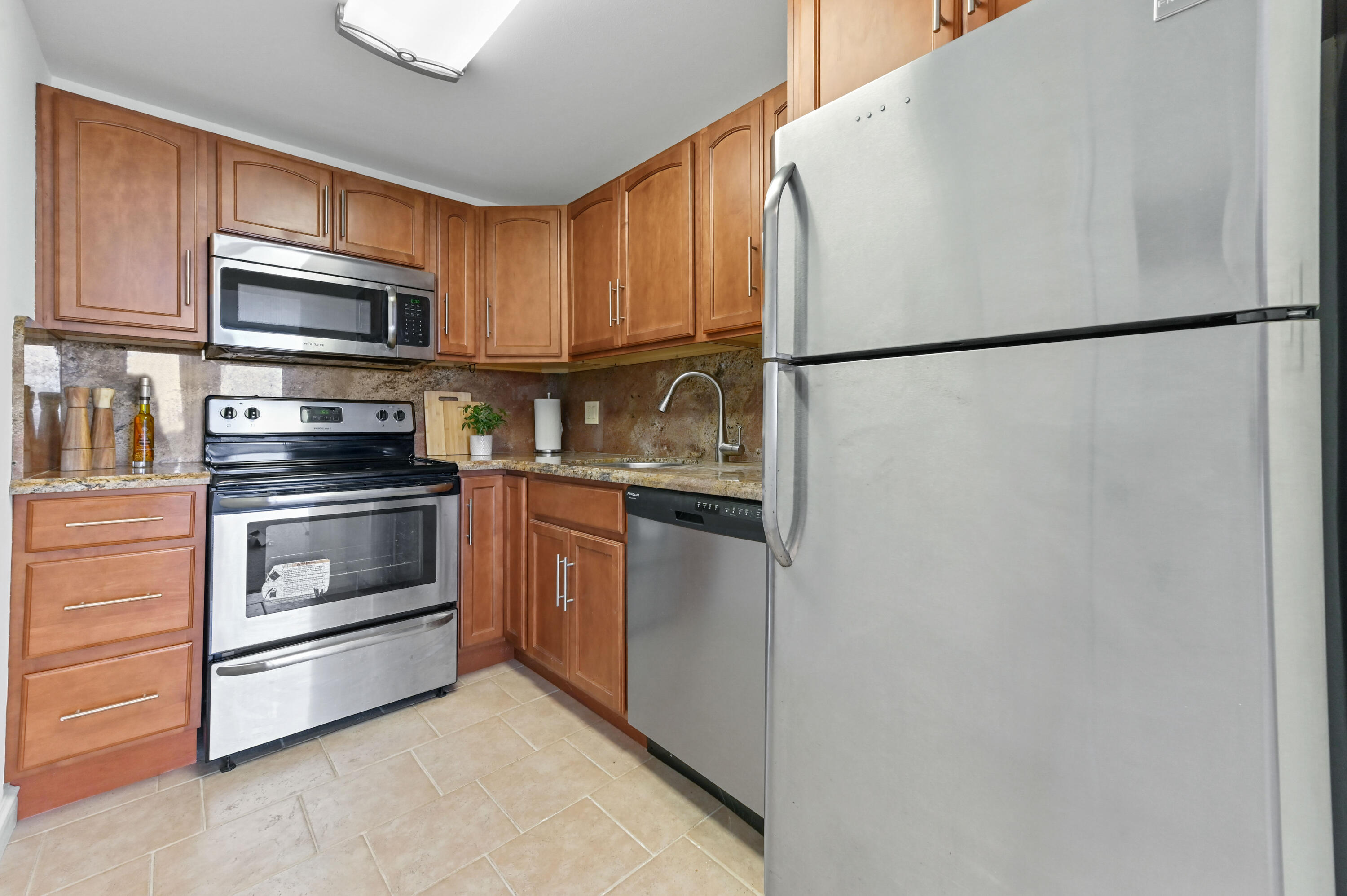 555 Northwest 4th Avenue, Unit 5070 Boca Raton, FL 33432 - Photo 10 of 29 a kitchen with stainless steel appliances granite countertop a refrigerator a stove a sink and a microwave