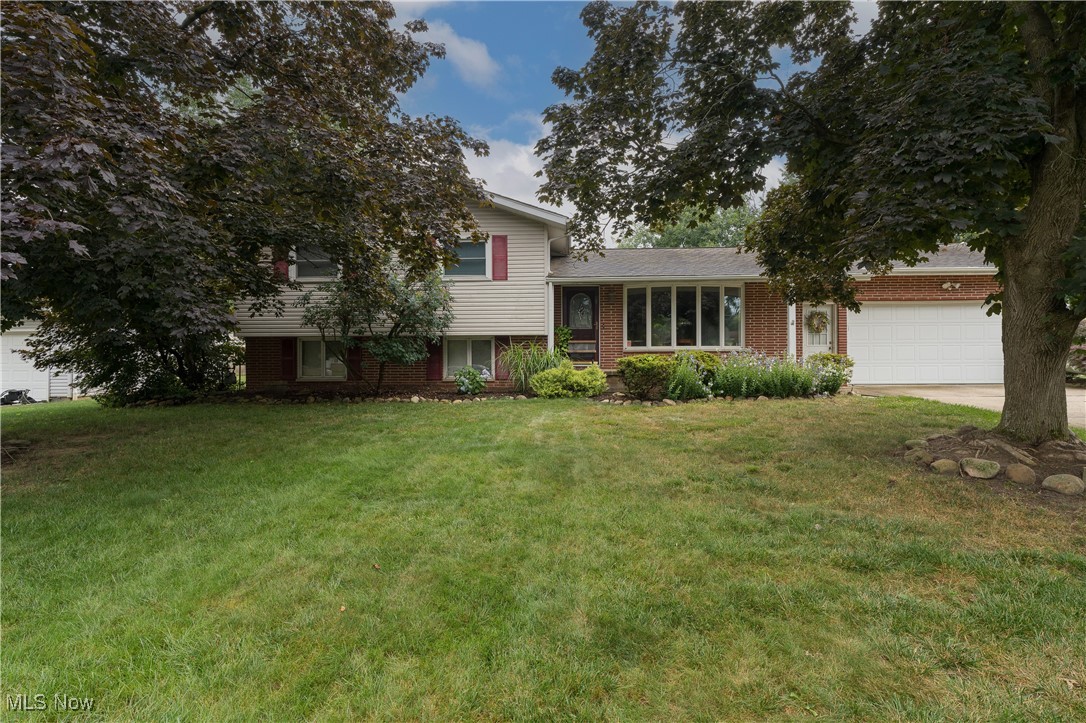 2856 Shellhart Road Barberton, OH 44203 - Photo 2 of 27 Split level home with brick siding, a front yard, driveway, and a garage