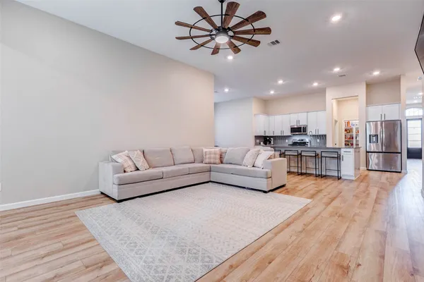 a living room with furniture and a wooden floor