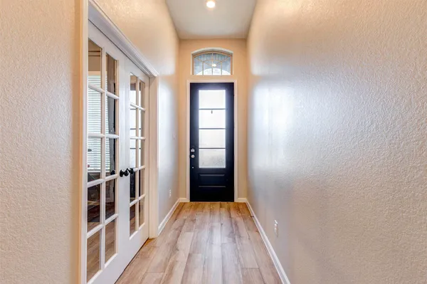 a view of a hallway with wooden floor and entryway