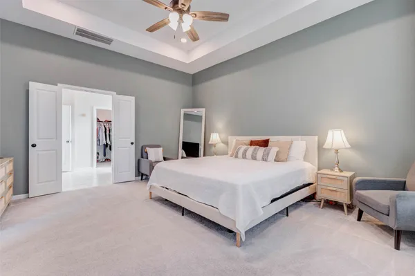 a spacious bedroom with a bed and a chandelier