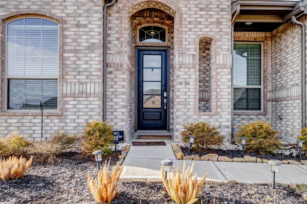 a view of a brick house with potted plants