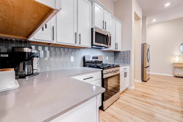 a kitchen with stainless steel appliances a stove microwave and sink