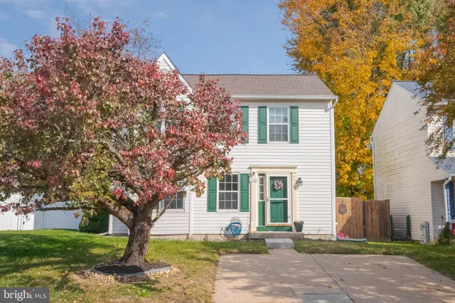 a front view of a house with a tree and a yard